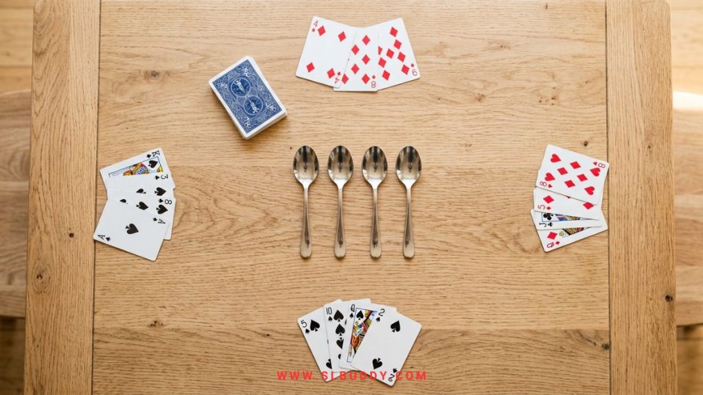 spoons game setup 2026 Spoons card game setup showing spoons, draw pile, and four cards per player
